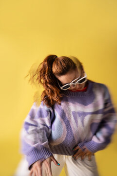 Young woman dancer in trippy lens effect on yellow backdrop
