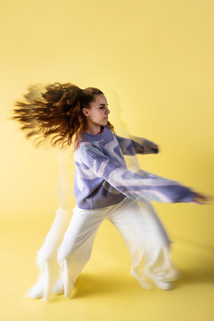 Young woman dancer in trippy lens effect on yellow studio