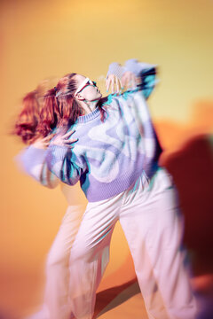 Young woman dancer in trippy lens effect with neon light