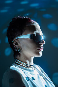 Cyberpunk woman in visor glasses with neon blue light