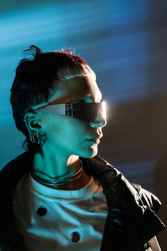 Cyberpunk woman portrait in neon light with visor glasses