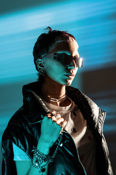 Cyberpunk woman in neon light with sunglasses and jacket