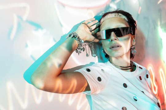 Cyberpunk woman in visor sunglasses with neon lighting