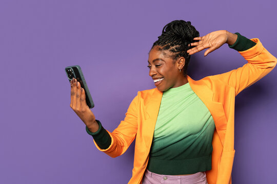 Young afro woman taking selfie with smartphone in studio