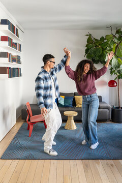 Latin couple dancing together in a modern living room