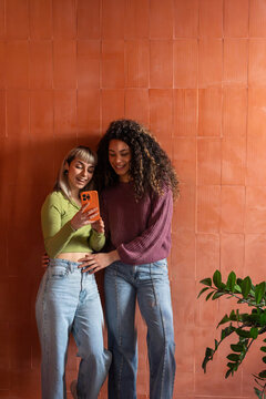 Multiethnic flatmates taking a selfie at home together