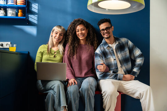 Multiethnic flatmates relaxing together in modern kitchen