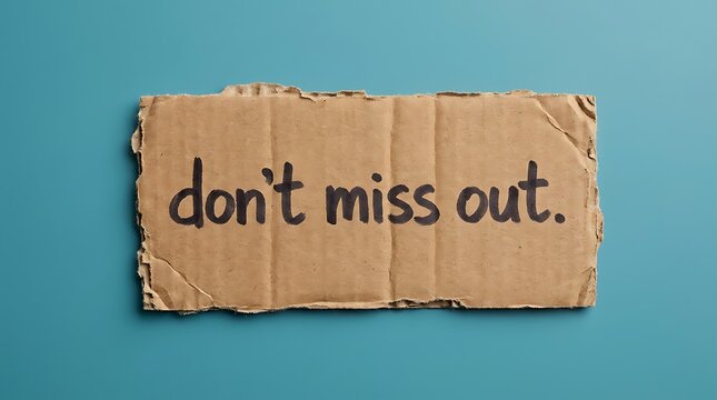 Cardboard sign with text don't miss out written in black marker, representing a call to action or reminder against blue background.