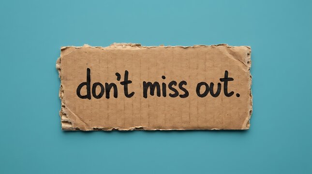 Textured cardboard sign featuring handwritten message don t miss out isolated on soft blue studio background representing urgent call to action or promotional marketing announcement.