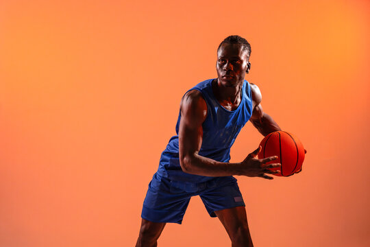 Black basket man dribbling ball on orange background