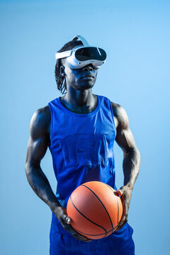 Black basketball player wearing VR headset holding ball