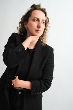 Thoughtful woman in black suit portrait on white backdrop