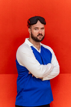Athlete in goalball gear standing against red background