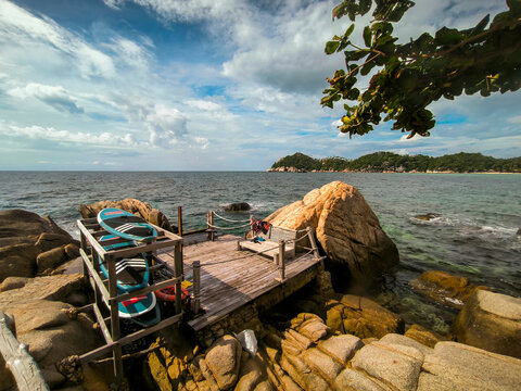 Rocky seaside deck with paddleboards on Koh Tao, Thailand