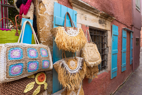 Handcrafted straw bags on blue shutters in Chania, Crete