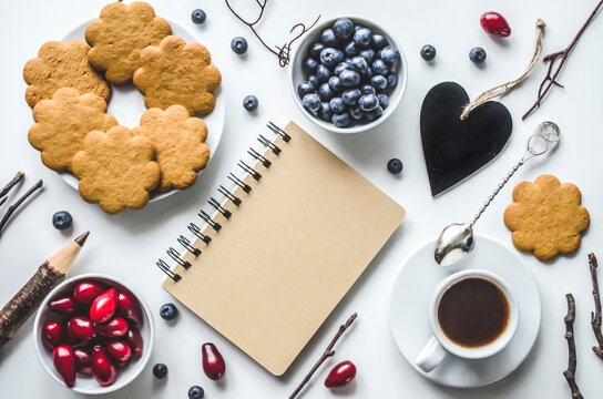 Cozy flat lay with notebook, coffee, berries and cookies