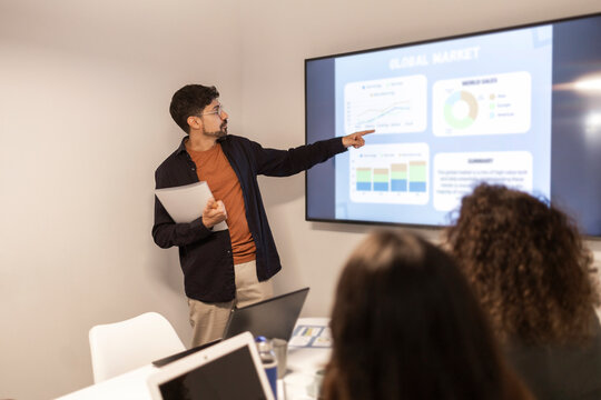 Team brainstorming in coworking office with data presentation