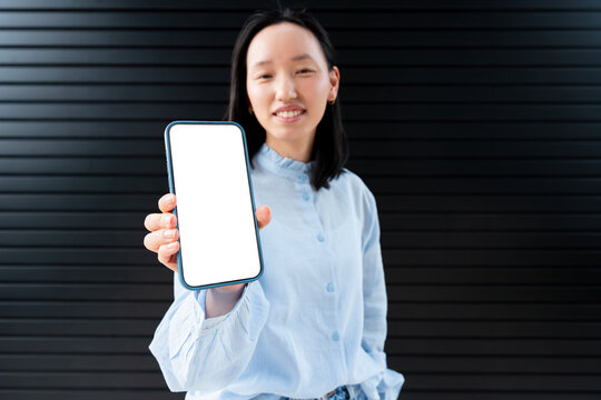 Gen Z Asian woman showing blank smartphone screen mockup
