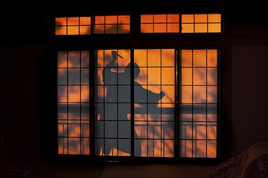 Shadow of a man, burglar with knife, assassin, ninja, on the balcony behind sliding shoji doors in a traditional Japanese house, Yamanouchi, Nagano, Japan