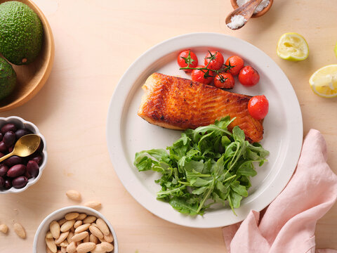 Pan-seared salmon filet served with cherry tomatoes and arugula
