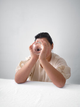 Woman gazing through crystal ball in minimal studio light