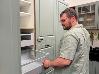Fototapeta premium Customer choosing kitchen cabinets in a modern kitchen showroom