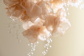 Fototapeta premium Delicate fabric flowers and bubbles hang from the ceiling in a bright indoor space during daylight hours
