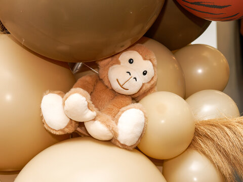 Peluche de singe au c&oelig;ur d'une arche de ballons aux couleurs safari pour d&eacute;coration d'anniversaire ou baby shower