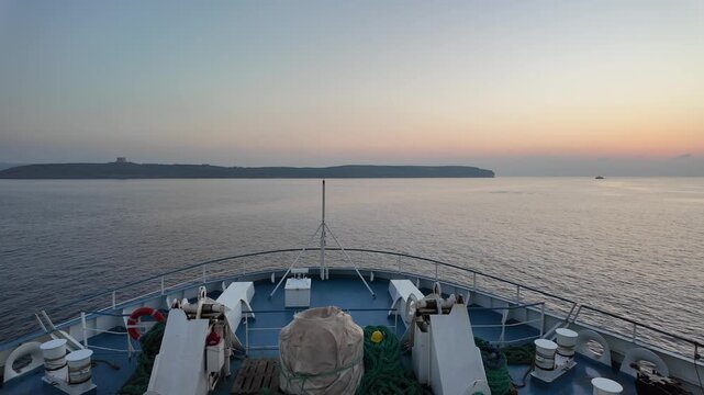 serene seascape at dusk with boats and sailboats on the ocean during sunset from a ship or dock, looking out to distant landmasses Comino Island and calm waters with blue and gray hues.Malta. High