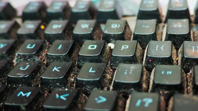 Dirty computer keyboard covered in dust and food debris workplace hygiene concept