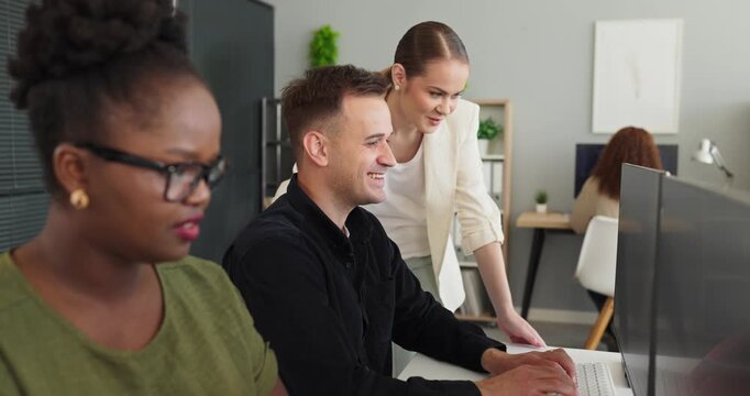 Developers and programmers discuss code review teamwork. A team collaborates at computers as a leader guides problem solving in an office. Strong teamwork drives innovative software solutions.