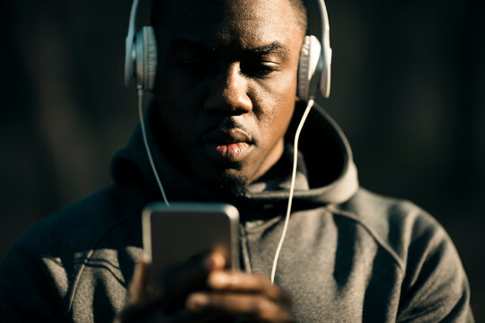 Young man listening to music on smartphone outdoors