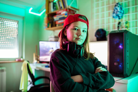 Confident teen gamer with headset in neon lit bedroom