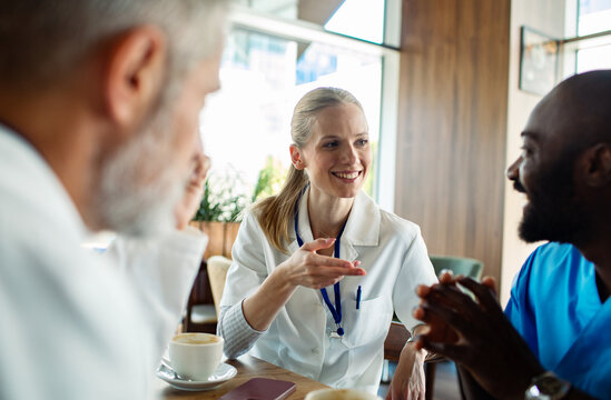 Smiling healthcare colleagues discussing work in cafe