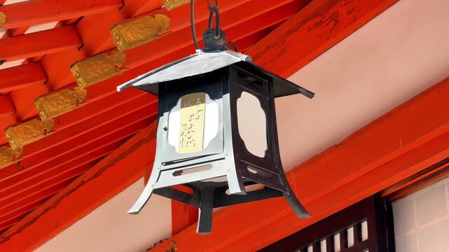 Traditional Hanging Lantern Attached to a Bright Vermilion Shrine Roof