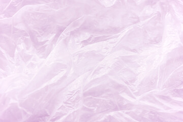 Fototapeta premium Crumpled wrinkled pink plastic bag texture background. Reuse recycle concept.