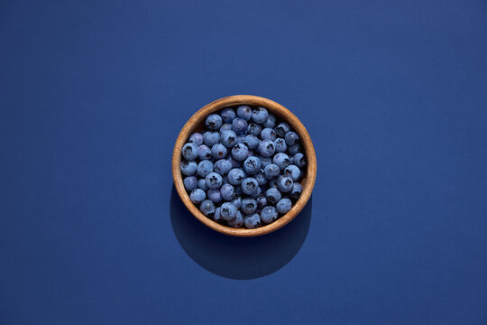 Fresh organic blueberries in a wooden bowl, minimal food concept