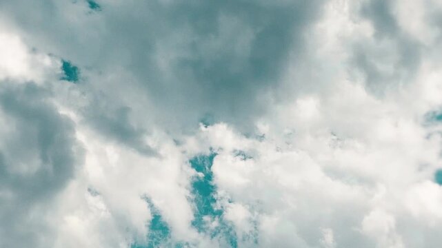 Cinematic teal color graded dramatic sky with heavy white clouds and blue breaks, stylized film look summer sky timelapse as a scenic background for travel lifestyle and outdoor content 16:9