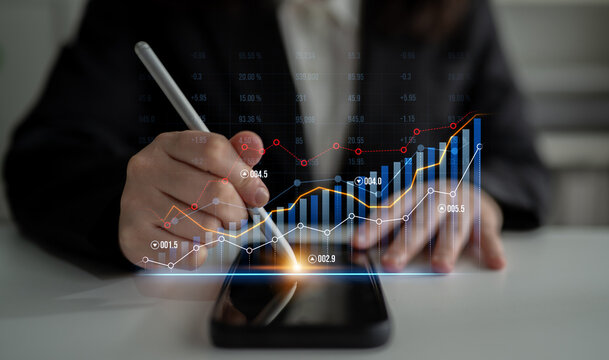 A business professional uses a smartphone to examine financial data with digital charts and graphs, highlighting market trends and strategic insights for effective decision-making. Scalp