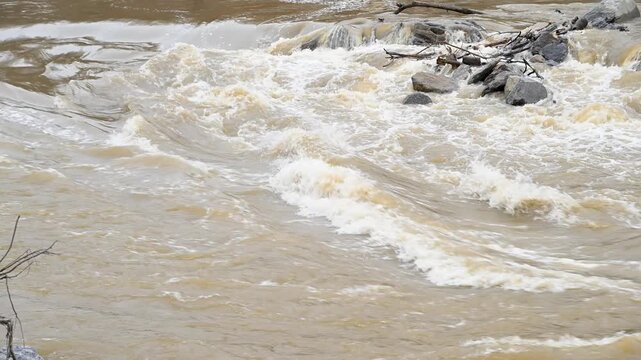 Rapid flowing, muddy waters below and across the Nolichucky Dam located in Greene County, Tennessee.