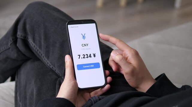 Clean smartphone interface displaying the current USD to Chinese Yuan market rate. User prepares to convert currency via a mobile trading app.