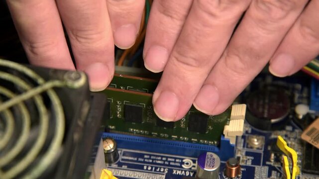 Inserting a RAM memory stick into desktop computer mainboard slot close up