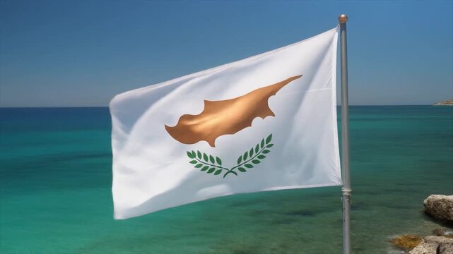 The national flag of Cyprus waving proudly on a flagpole against a clear blue sky and turquoise sea with rocky coastline in the background