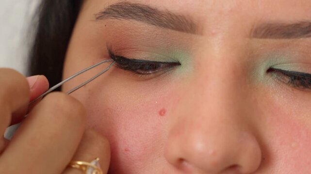 Makeup artist applying false eyelashes to a woman