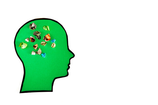 Clean conceptual art of a green head silhouette filled with colorful crumpled paper balls representing chaotic thoughts