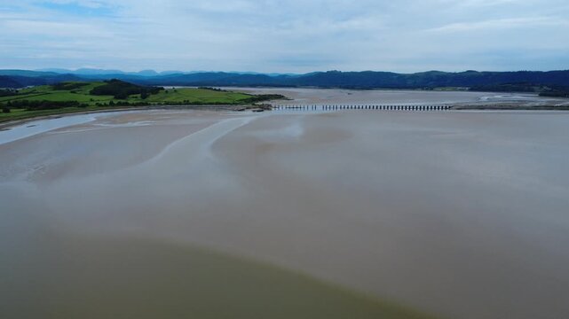 high aerial view of Arnside railway viaduct in Cumbria showing the river Kent running into Morecambe Bay near Grange over Sands