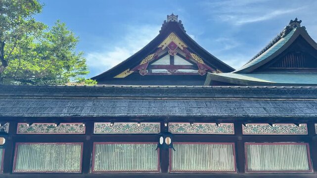 Close view of traditional Japanese shrine rooflines under blue sky