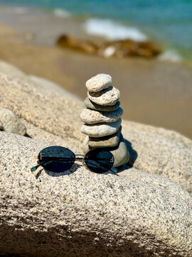 A beautiful photo of round stones against the backdrop of the sea. Glasses against the backdrop of the ocean.