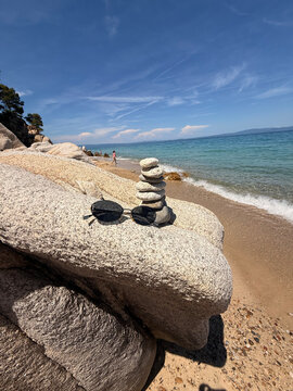 A beautiful photo of round stones against the backdrop of the sea. Glasses against the backdrop of the ocean.