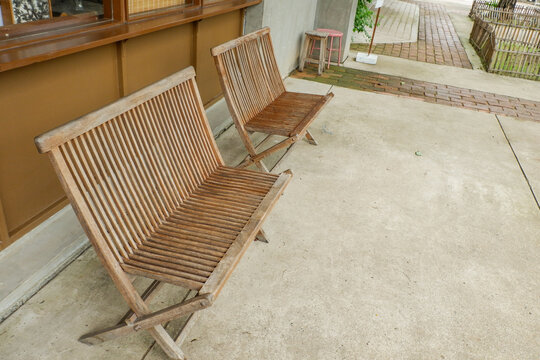 Wooden table and chair set in garden on a sunny day,outdoor seating for restaurant or cafe,Neat paved patio with sitting area and small garden in forest.